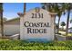 Coastal Ridge deed restricted community sign with tropical landscaping on a sunny day at 2131 Ridge S Rd # 3, Largo, FL 33778