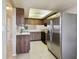 Well-lit kitchen features wood cabinets, stainless refrigerator, and tile flooring at 2131 Ridge S Rd # 3, Largo, FL 33778