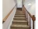 Carpeted staircase with wooden banister and railing leading to the upper level of the home at 2131 Ridge S Rd # 3, Largo, FL 33778
