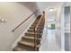 Elegant staircase with plush carpeting, a wooden railing, and a view into the tiled hallway at 2131 Ridge S Rd # 3, Largo, FL 33778