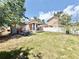 Large backyard with grass, and an orange home with a covered porch and white fencing at 2137 W Saint Louis St, Tampa, FL 33607