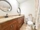 Bathroom featuring double sinks, wooden cabinets, and a toilet with tiled floors and granite countertops at 2137 W Saint Louis St, Tampa, FL 33607