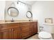 Bathroom with a double sink, granite countertop, and two decorative round mirrors hanging above the countertop at 2137 W Saint Louis St, Tampa, FL 33607