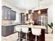 Modern kitchen with dark wood cabinets, stainless steel appliances, granite countertops, and island seating at 2137 W Saint Louis St, Tampa, FL 33607