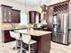 Well-lit kitchen with granite countertops, stainless steel appliances, and dark wood cabinetry at 2137 W Saint Louis St, Tampa, FL 33607