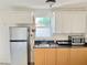 Bright kitchenette with stainless steel refrigerator, white cabinets and granite countertops at 2137 W Saint Louis St, Tampa, FL 33607