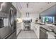 Modern white kitchen featuring stainless steel appliances, granite countertops, and tile backsplash at 2335 Beneva Ter # 2254, Sarasota, FL 34232