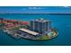 Aerial view of waterfront condo building, marina, pool, and lush landscaping in a coastal setting at 240 Sand Key Estates Dr # 222, Clearwater, FL 33767