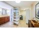 Bathroom and closet featuring tiled floor, wood cabinet, dual sinks, and open shelving at 240 Sand Key Estates Dr # 222, Clearwater, FL 33767