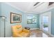 Bright sitting area with a yellow chair and beautiful views of the water at 240 Sand Key Estates Dr # 222, Clearwater, FL 33767