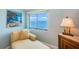 Relaxing bedroom corner featuring water views, natural light, and a cozy chaise lounge at 240 Sand Key Estates Dr # 222, Clearwater, FL 33767