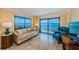 Inviting living room featuring balcony access, water views, and comfortable furniture at 240 Sand Key Estates Dr # 222, Clearwater, FL 33767
