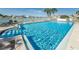 Sparkling community pool with spa and lounge area, surrounded by lush landscaping and nearby buildings at 240 Sand Key Estates Dr # 222, Clearwater, FL 33767