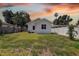 Spacious backyard with a well-maintained lawn, privacy fence, and mature trees at sunset at 2627 17Th N Ave, St Petersburg, FL 33713