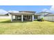 View of the backyard, showing the house with a screened lanai at 30572 Thunderbird Dr, Wesley Chapel, FL 33545