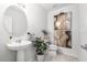 Modern powder room featuring stylish pedestal sink and decorative wall art at 30572 Thunderbird Dr, Wesley Chapel, FL 33545