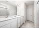 Bright bathroom featuring double sinks, white cabinets, and tiled shower at 30572 Thunderbird Dr, Wesley Chapel, FL 33545