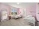 Charming bedroom with pink walls, twin beds, and stylish decor creating a cozy and inviting atmosphere at 30572 Thunderbird Dr, Wesley Chapel, FL 33545