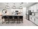 Modern kitchen features stainless steel appliances, white cabinetry, a large island, and pendant lighting at 30572 Thunderbird Dr, Wesley Chapel, FL 33545