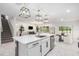 Open-concept kitchen with white cabinets, stainless steel appliances, a center island, and seamless flow to the dining area at 30572 Thunderbird Dr, Wesley Chapel, FL 33545