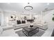 Bright living room with contemporary sofas, modern decor, and an open layout connecting to the kitchen at 30572 Thunderbird Dr, Wesley Chapel, FL 33545