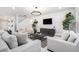 Inviting living room with a neutral color palette, stylish furniture, large windows, and a decorative chandelier at 30572 Thunderbird Dr, Wesley Chapel, FL 33545