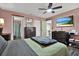 This bedroom features a ceiling fan, hard wood floors and TV and leads to a bathroom and another room at 3229 40Th S Ln # C, St Petersburg, FL 33711