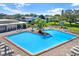 Community pool with lounge seating, umbrellas, and manicured landscaping in a well-maintained neighborhood at 3229 40Th S Ln # C, St Petersburg, FL 33711
