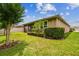 Well-maintained backyard with a lush lawn, verdant hedges, and a screened-in patio for outdoor living at 32825 Sand Creek Dr, Wesley Chapel, FL 33543