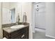 Bathroom features granite countertop with dark cabinets and decorative mirror at 32825 Sand Creek Dr, Wesley Chapel, FL 33543
