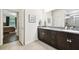 Modern bathroom featuring double sinks, granite countertop, and a glass-enclosed shower at 32825 Sand Creek Dr, Wesley Chapel, FL 33543