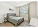 Bright bedroom featuring a large window, comfortable bed, wood-look floors, and natural light at 32825 Sand Creek Dr, Wesley Chapel, FL 33543