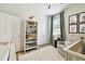 Well-decorated bedroom, featuring a cozy chair, bookshelf, and neutral color palette at 32825 Sand Creek Dr, Wesley Chapel, FL 33543