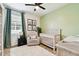 Cozy Bedroom featuring a neutral color palette, ceiling fan, comfortable chair, and plenty of natural light at 32825 Sand Creek Dr, Wesley Chapel, FL 33543