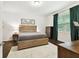 Cozy bedroom featuring a wooden bed frame, neutral decor, and a large window at 32825 Sand Creek Dr, Wesley Chapel, FL 33543