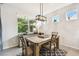 Bright dining area with a modern chandelier and views of the lush greenery outside at 32825 Sand Creek Dr, Wesley Chapel, FL 33543