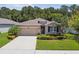 Charming home with a well-manicured lawn, stone accents, and a two-car garage, showcasing curb appeal at 32825 Sand Creek Dr, Wesley Chapel, FL 33543