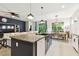 Open-concept kitchen featuring granite island, stainless appliances, and a seamless flow to the dining area at 32825 Sand Creek Dr, Wesley Chapel, FL 33543