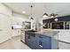 Open kitchen with island, granite countertops, and stainless appliances flows into the living room at 32825 Sand Creek Dr, Wesley Chapel, FL 33543