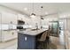 Bright kitchen features granite counters, a dark island with seating, stainless appliances and subway tile backsplash at 32825 Sand Creek Dr, Wesley Chapel, FL 33543