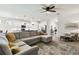Spacious living room boasts a large sectional sofa, stylish rug, and an open concept design to the kitchen at 32825 Sand Creek Dr, Wesley Chapel, FL 33543