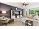 Spacious living room features an entertainment center, comfortable seating, ceiling fan, and neutral-toned tile flooring at 32825 Sand Creek Dr, Wesley Chapel, FL 33543