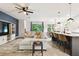 Open concept living area featuring tile flooring, a comfortable sectional, and modern kitchen at 32825 Sand Creek Dr, Wesley Chapel, FL 33543