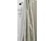 Closeup of a white-tiled shower with stylish patterned curtain at 32825 Sand Creek Dr, Wesley Chapel, FL 33543