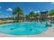 Community splash pad featuring a turquoise surface, various fountains, and palm trees against a bright blue sky at 32825 Sand Creek Dr, Wesley Chapel, FL 33543