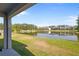 A serene pond view from the backyard with manicured lawn, and other homes in the distance at 3334 Pleasant Willow Ct, Brandon, FL 33511