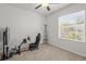 Neutral bedroom featuring plush carpet and natural light, complete with ceiling fan and a racing simulator at 3334 Pleasant Willow Ct, Brandon, FL 33511