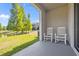 Private, covered patio with rocking chairs overlooks a lush green lawn and tranquil pond at 3334 Pleasant Willow Ct, Brandon, FL 33511