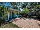 Outdoor seating and brick patio in backyard surrounded by lush greenery at 420 Roanoke St, Dunedin, FL 34698
