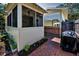 Exterior view of the backyard patio, showcasing the screened porch and beautiful brick pavers at 420 Roanoke St, Dunedin, FL 34698